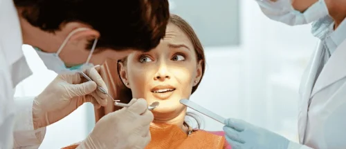 Nervous young woman in the dental chair with a dentist
